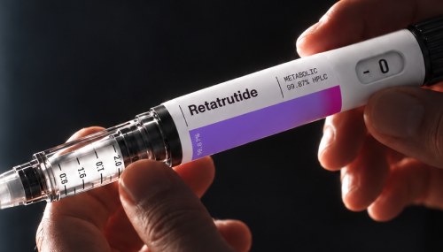 A Retatrutide research pen held between two fingers